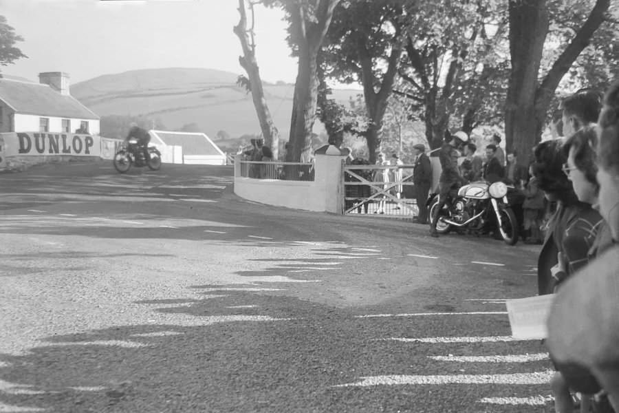 George E. Leigh (#18) stopped by the side of the road as another passes over Ballaugh Bridge