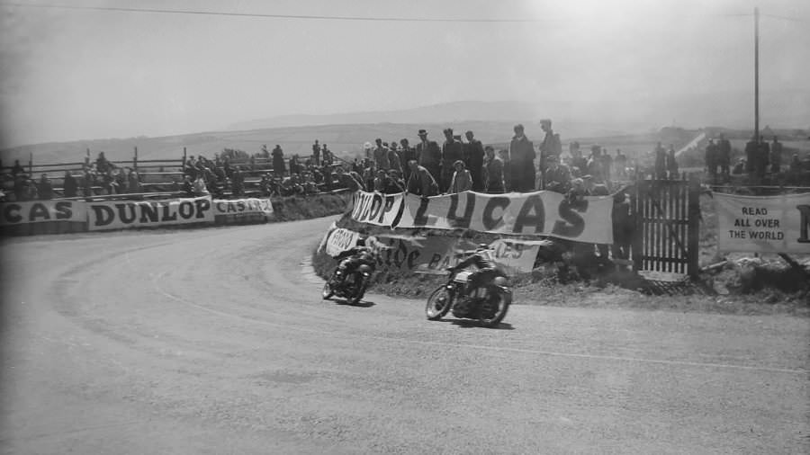 Two riders are jostling for position as they speed past Creg-ny-Baa, the crowds clearly enthused by the sight